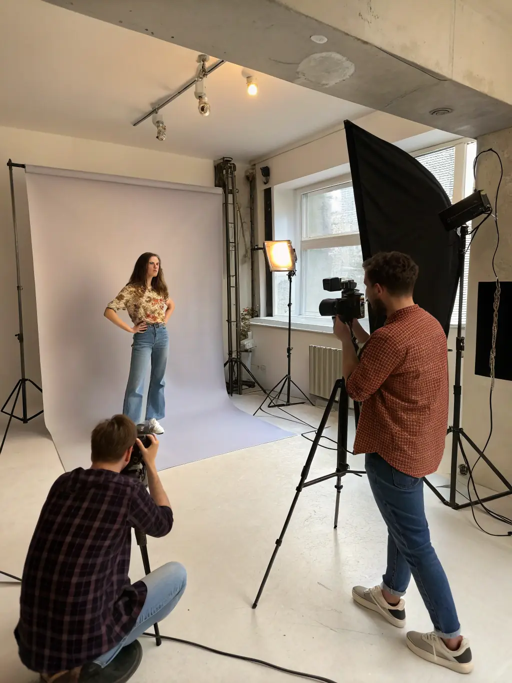A group of participants actively engaged in a photography workshop, focusing on portrait lighting techniques, set in a professional studio environment with various lighting setups.